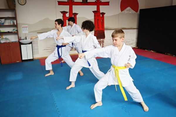 uczestnicy karate w białych kimonach podczas zajęć