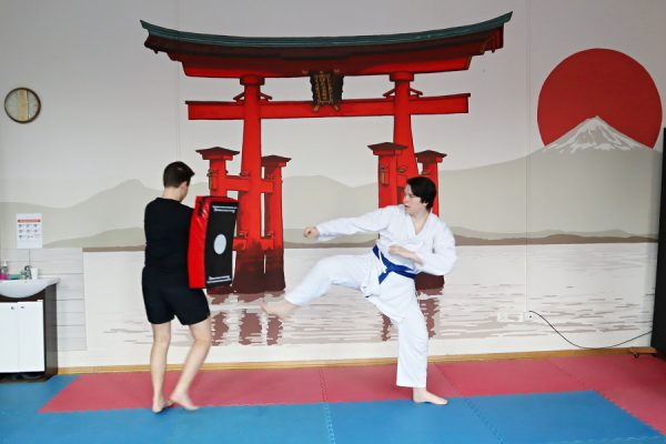 uczestnicy karate w białych kimonach podczas zajęć