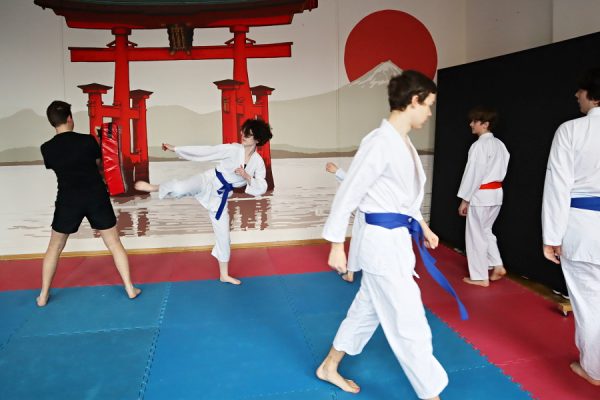uczestnicy karate w białych kimonach podczas zajęć