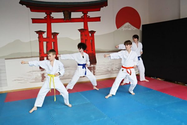 uczestnicy karate w białych kimonach podczas zajęć