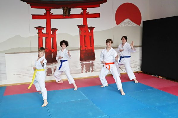 uczestnicy karate w białych kimonach podczas zajęć