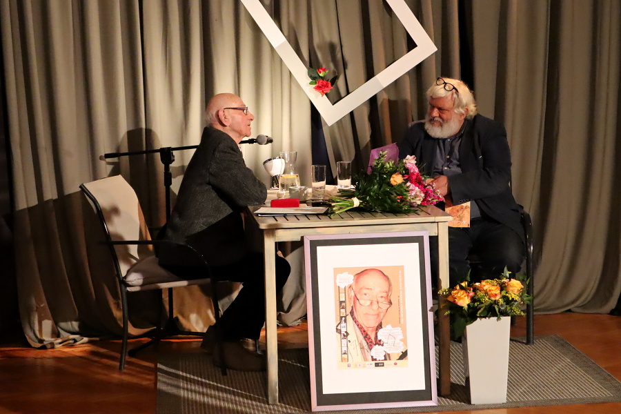 dwóch mężczyzn przy stole podczas spotkania literackiego