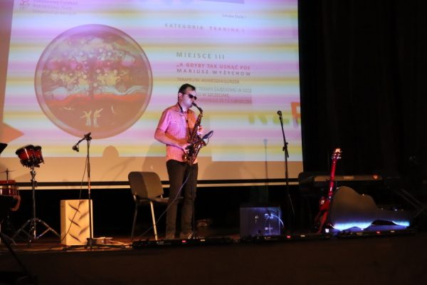 młody człowiek grajacy na saksofonie