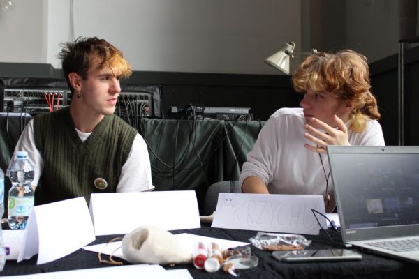 grupa młodzieży siedząca przy stole i grające w gry RPG