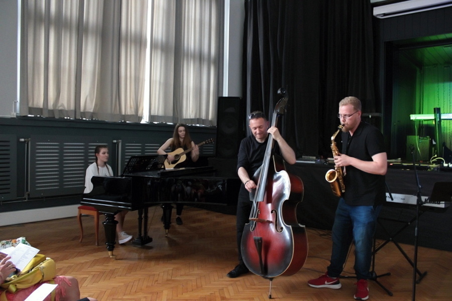 trzy osoby na scenie podczas koncertu