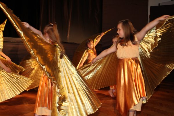 dziewczęta w złotych strojach w pozie tanecznej