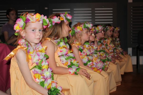 dziewczęta w strojach hawajskich siedzą