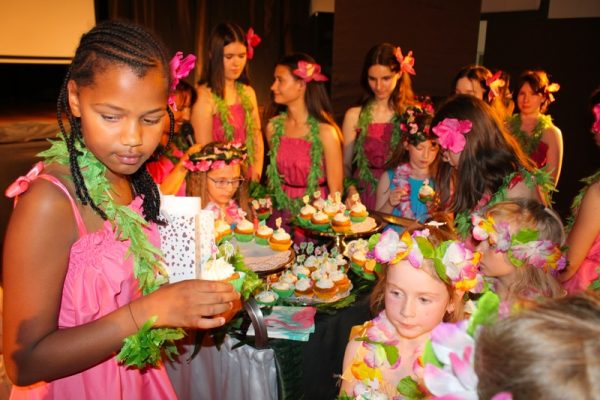dziewczęta w strojach hawajskich ze słodkimi babeczkami