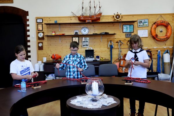 troje dzieci w sali edukacji morskiej podczas testu praktycznego