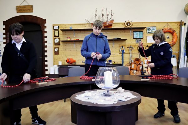 troje dzieci w sali edukacji morskiej podczas testu praktycznego