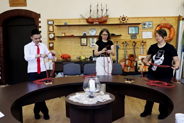 troje dzieci w sali edukacji morskiej podczas testu praktycznego