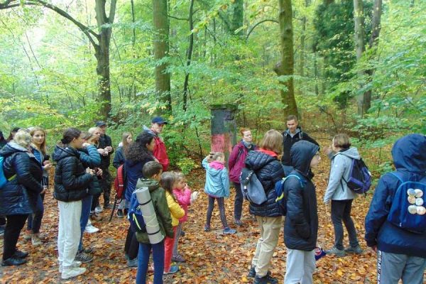 uczniowie na drodze leśnej przed wejściem do dawnego Sanatorium Zdroje