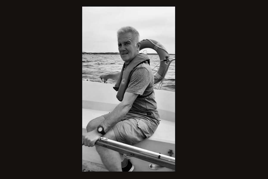 mężczyzna trzymajacy wiosło za nim koło ratunkowe