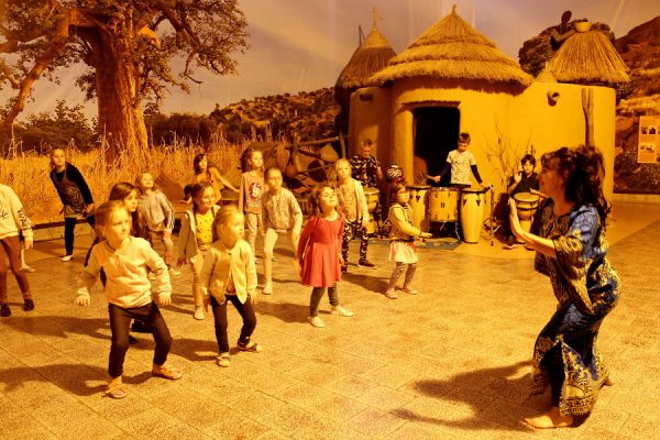 grupa dzieci tańczy w przestrzeni wioski afrykańskiej