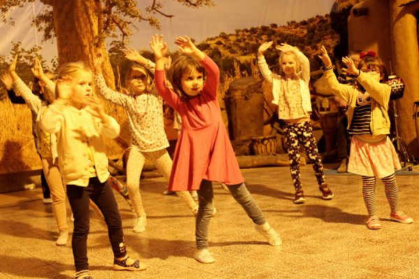 grupa dzieci tańczy w przestrzeni wioski afrykańskiej