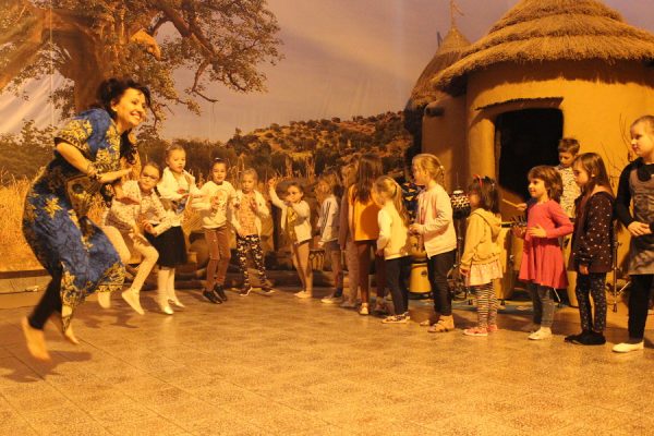 grupa dzieci tańczy w przestrzeni wioski afrykańskiej