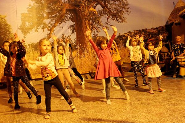 grupa dzieci tańczy w przestrzeni wioski afrykańskiej