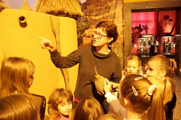 grupa dzieci otaczająca kobietę