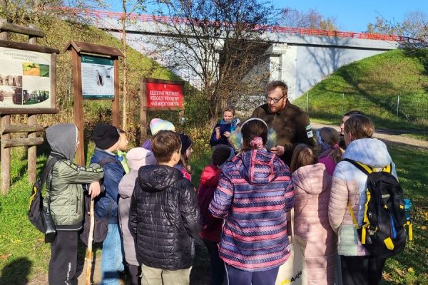 grupa dzieci stoi wokół mężczyzny