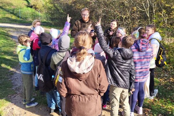 grupa dzieci skupiona wokół mężczyzny