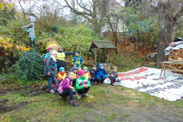 rok 2015, grupa dzieci na tle rzeźby Słońce z napisem Uśmiechnij się!