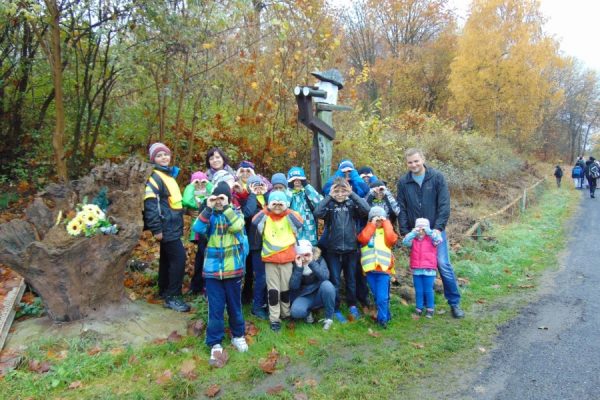 grupa dzieci na tle drewnianej rzeźby