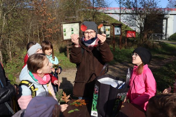 kobieta pokazuje dzieciom liście