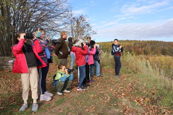 grupa dzieci patrzy przez lornetki