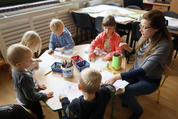 grupa dzieci siedzi przy stoliku