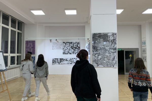 grupa młodzieży ogląda wystawę