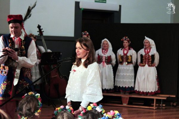 na pierwszym planie dyrektor placówki za nią grupa tancerzy