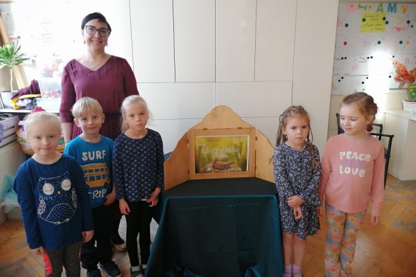 dzieci pozują do zdjęcia z nauczucielką