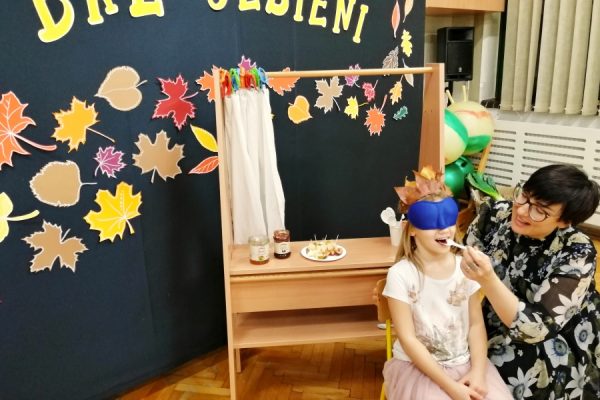 nauczycielka karmi dziecko łyżeczką