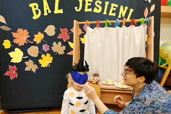 nauczcielka podaje dziecku coś na łyzeczce