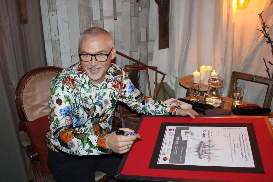 mężczyzna podpisujący plakat