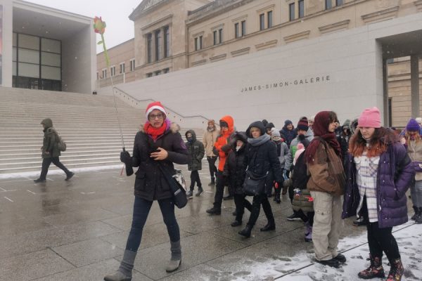 grupa osób idzie chodnikiem za przewodniczką