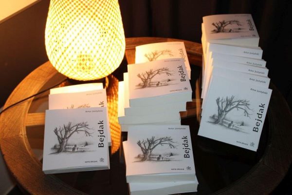 egzemplarze książek leżace na stoliku