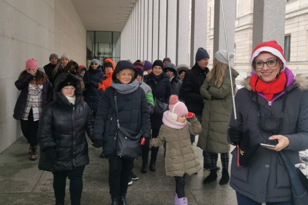 grupa ludzi idzie chodnikiem