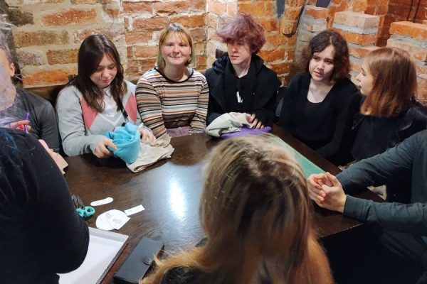 grupa młodzieży siedzi przy stole