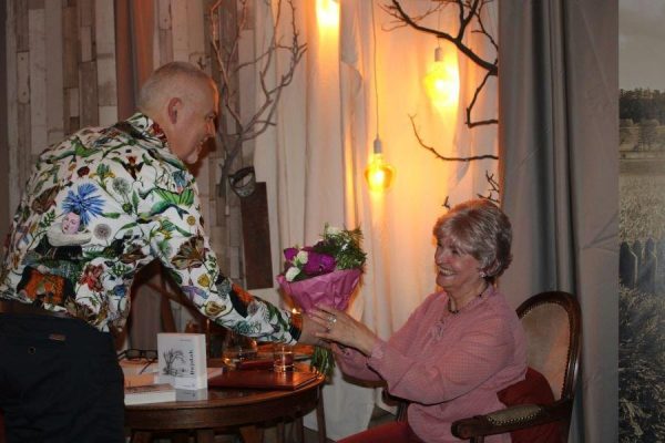 mężczyzna wręcza kobiecie bukiet kwiatów