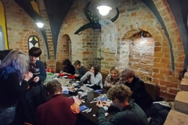 grupa młodzieży siedzi przy stole