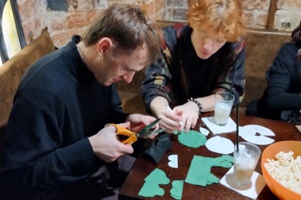 grupa młodzieży siedzi przy stole