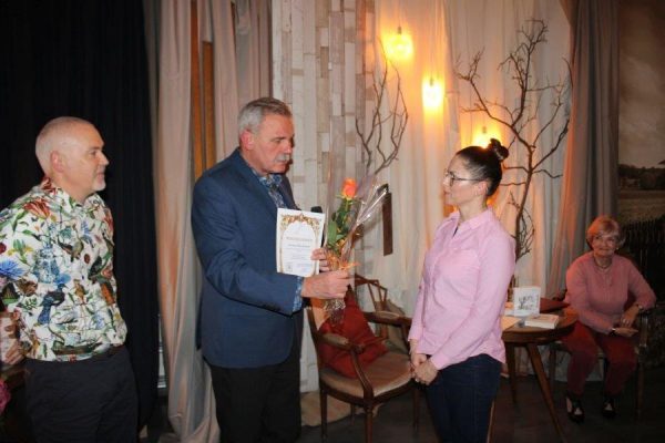 mężczyzna wręcza kobiecie kwiaty