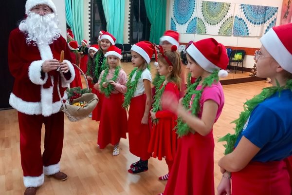 grupa dziewcząt ws trojach mikołajkowych stoi przy Mikołaju