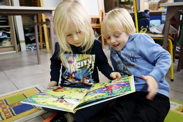 dwóch chłopców ogląda książkę