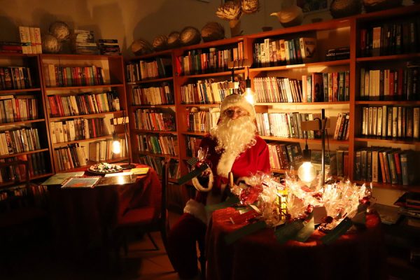 Mikołaj siedzi przy stoliku w bibliotece