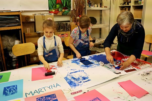 uczestnicy pracowni plastycznej podczas wykonywania odbitek