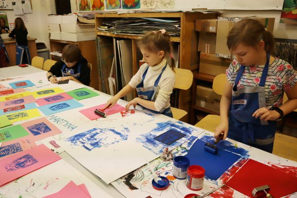 uczestnicy pracowni plastycznej podczas wykonywania odbitek