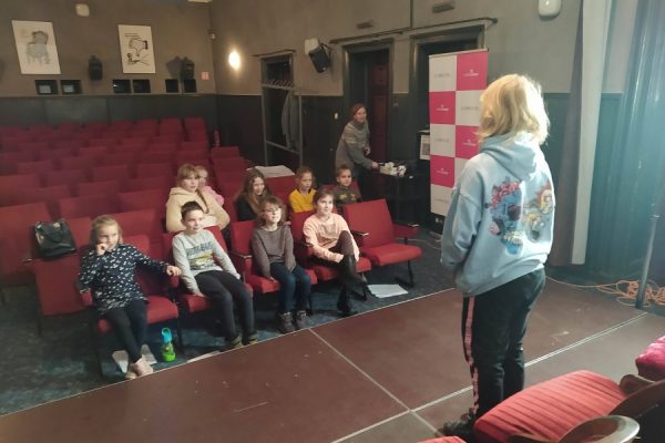 grupa młodzieży siedząca w fotelach