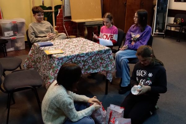 grupa młodzieży otwiera prezenty